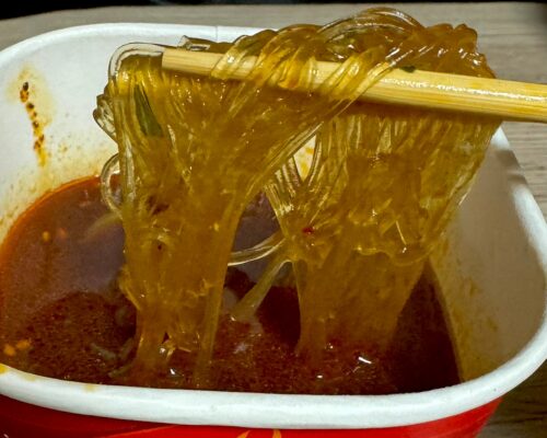 箸で持ち上げた透明感のあるモチモチの春雨麺（リフトアップ）